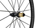 Close-up of a bicycle wheel with a gold hub on a white background