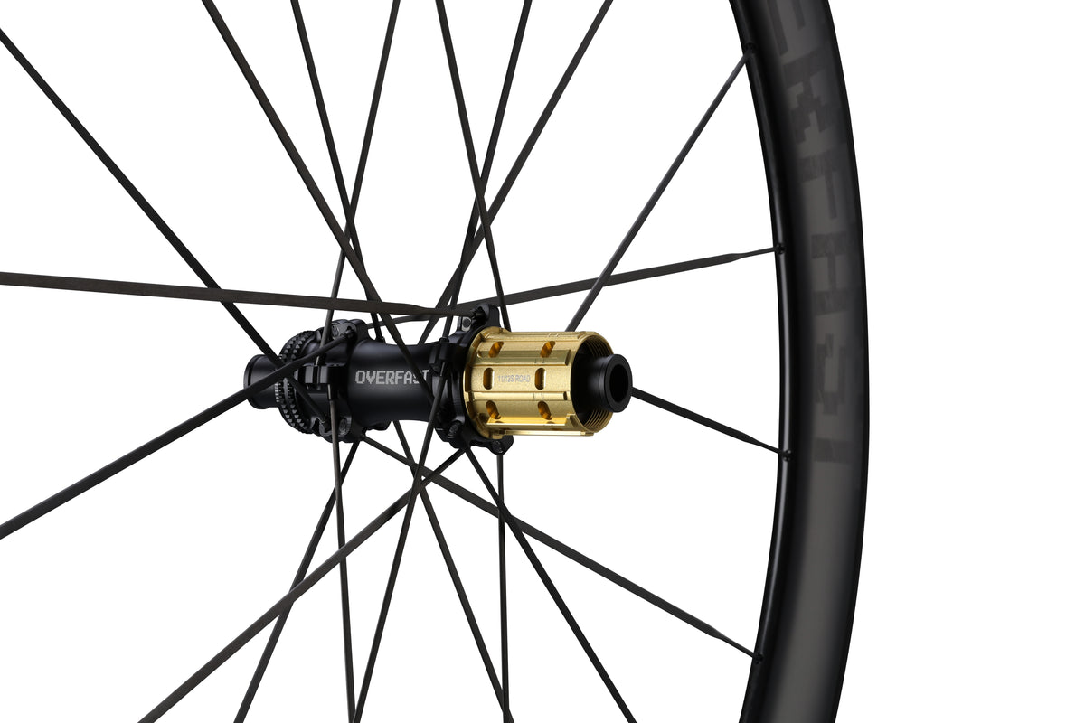 Close-up of a bicycle wheel with a gold hub on a white background