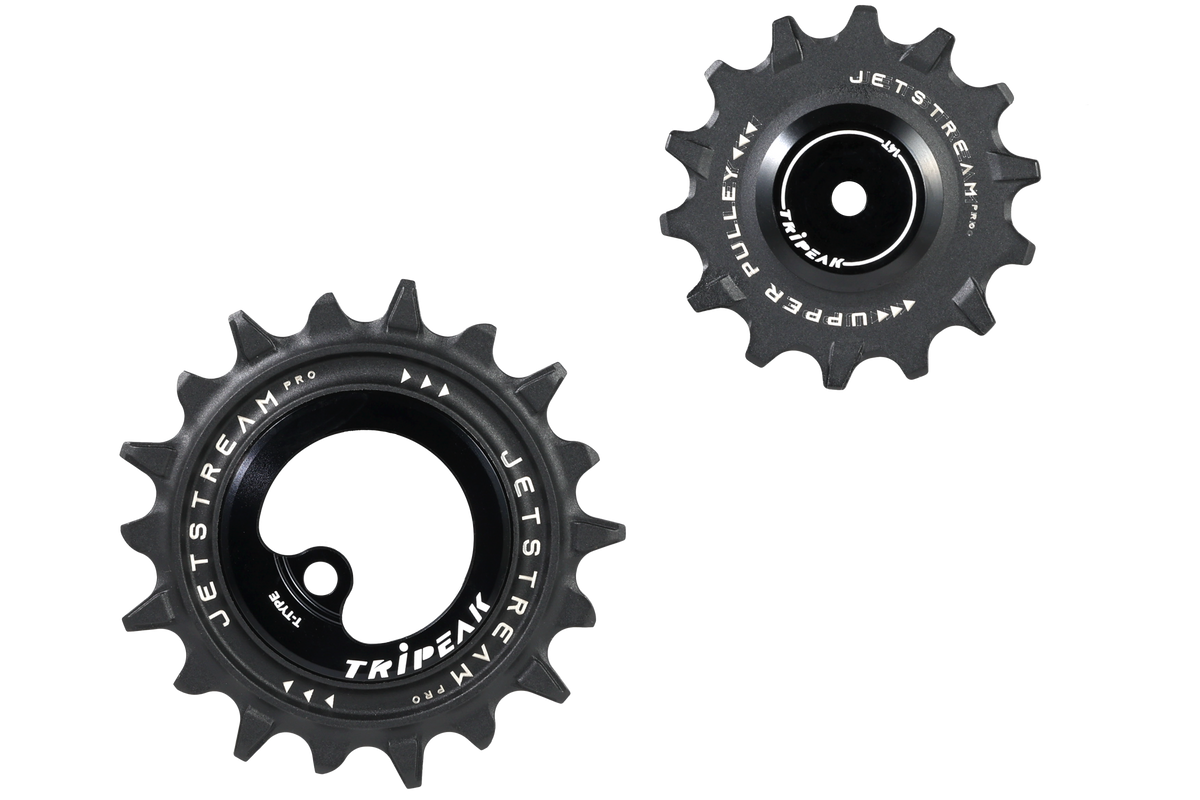 Two black Jetstream bicycle chaintensioner pulleys, one showing the front face with the Tripeak logo and the other showing the side profile, on a solid white background.