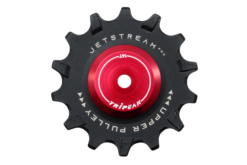 A black bicycle chain guard sprocket with a bright red center anodized hub, featuring white printed text that reads 'JETSTREAM PRO' and 'UPPER PULLEY' with 'TRIP EAK' in the center. The product is isolated on a solid white background.