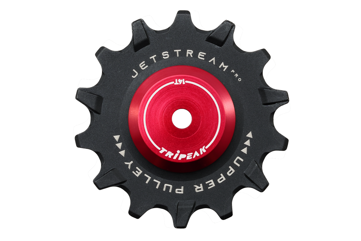 A black bicycle chain guard sprocket with a bright red center anodized hub, featuring white printed text that reads 'JETSTREAM PRO' and 'UPPER PULLEY' with 'TRIP EAK' in the center. The product is isolated on a solid white background.