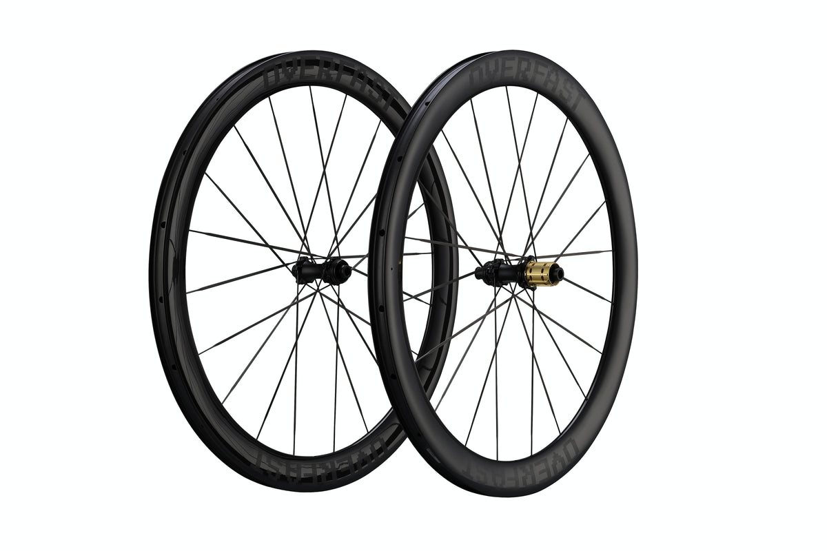 Two black carbon fiber road bicycle wheels with thin spokes and a gold hub accent, shown against a solid white background.
