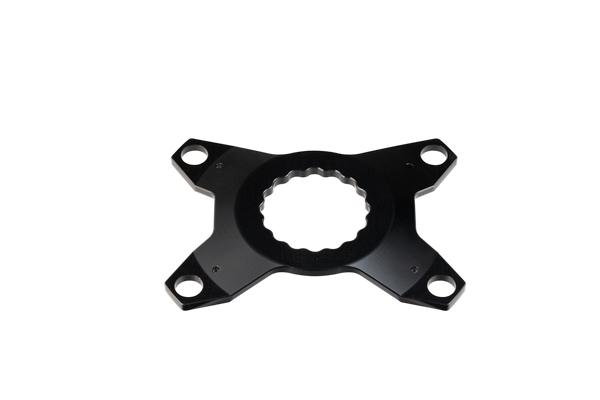 A black metal four-spoke wheel spacer with a central ring and four mounting holes, shown on a plain white background.